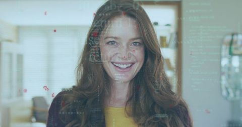 Smiling woman interacting with translucent digital code overlay in modern home kitchen