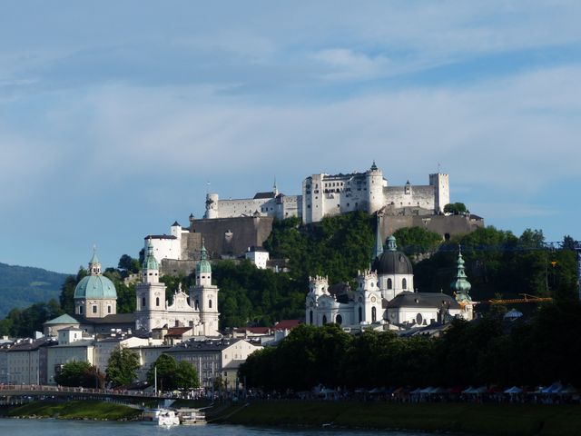 Beautiful view of Hohensalzburg Fortress overlooking the historic city of Salzburg with its classic European architecture and river. Ideal for travel magazines, tourism brochures, educational materials, and websites promoting European travel.