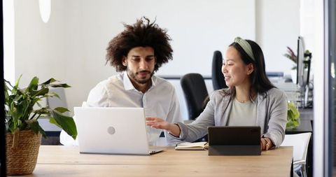 Diverse Colleagues Collaborating with Technology in Modern Office