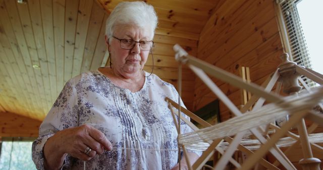 Senior Woman Working with Yarn in Cozy Cabin - Download Free Stock Images Pikwizard.com