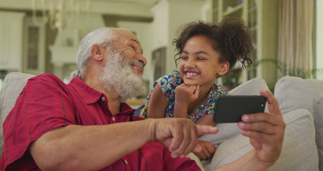 Grandfather Bonding with Granddaughter Using Smartphone at Home - Download Free Stock Images Pikwizard.com