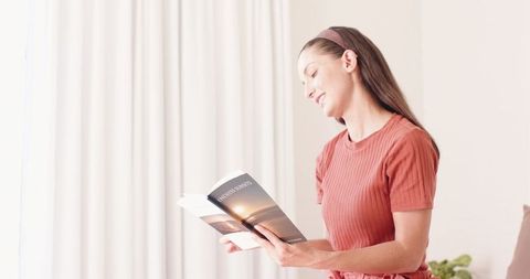 Woman Reading Book at Home in Sunlit Living Space