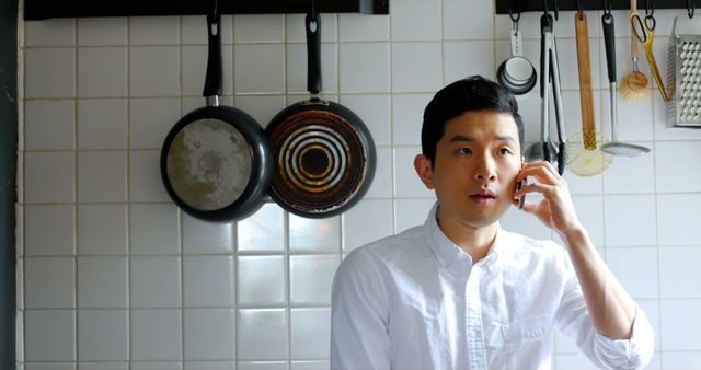 Young Asian Man Taking Phone Call in Modern Kitchen - Download Free Stock Images Pikwizard.com