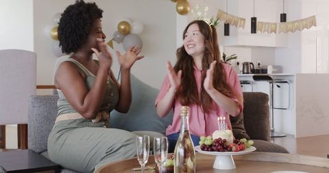Diverse Couple Celebrating Birthday with Cake and Balloons at Home