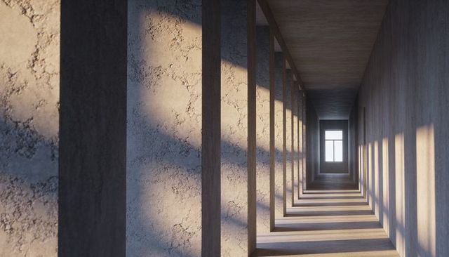 Sunlit concrete colonnade creating rhythmic shadows and depth toward window