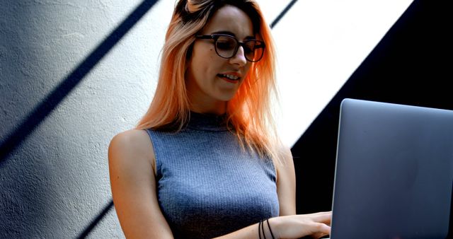 Young Woman Working on Laptop in Modern Urban Setting - Download Free Stock Images Pikwizard.com