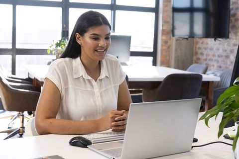Professional Woman Typing on Wireless Keyboard in Office Environment