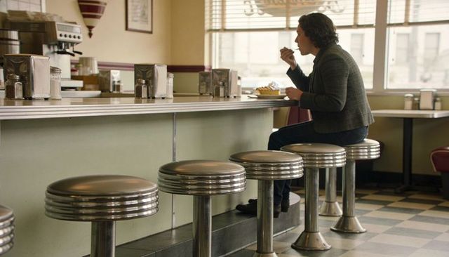 Solo diner customer enjoying classic american counter meal on chrome stools in retro diner