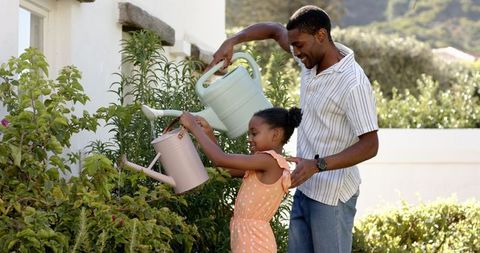Father and Daughter Nurturing Garden Together