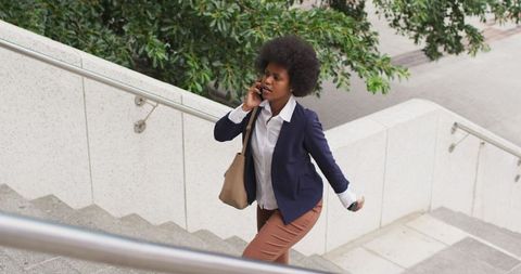 Businesswoman walking and talking on smartphone in urban setting