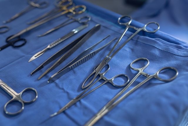 Close-up view of various surgical instruments neatly arranged on a table in an operation theater. Ideal for use in medical articles, healthcare websites, educational materials, and hospital brochures to illustrate surgical procedures and medical equipment.