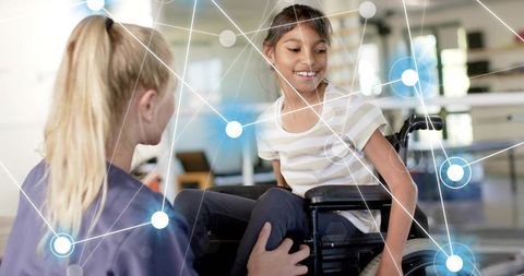 Smiling child in wheelchair receiving physical therapy support from caring therapist