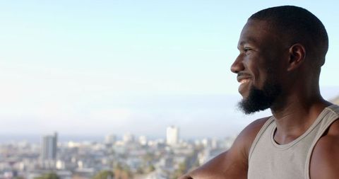 Reflective Man Enjoying Urban Skyline View from Balcony
