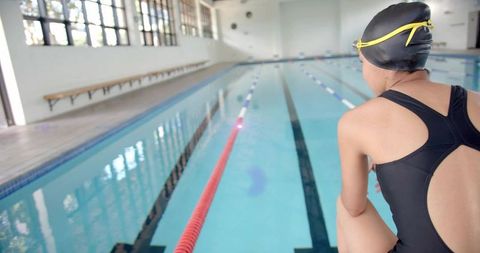 Swimmer contemplating at indoor pool