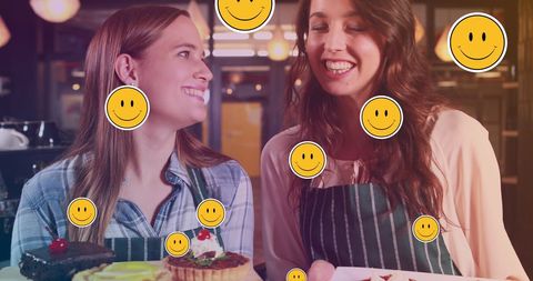 Joyful female bakers sharing smiles in bakery setting