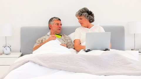 Senior Couple Online Shopping from Bed