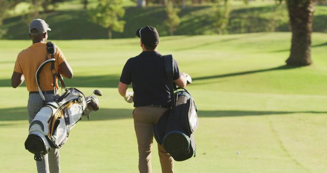 Two Golfers Walking on Golf Course with Bags - Download Free Stock Photos Pikwizard.com