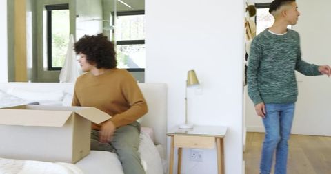 Roommates unpacking in modern bedroom setting