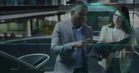 Business colleagues analyzing data on tablet with digital overlay