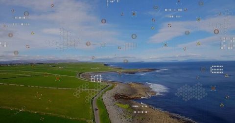 Drone navigating coastal road revealing curved bay with geospatial hud overlay mapping