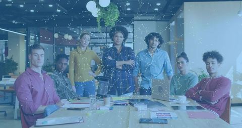 Diverse startup team collaborating around conference table with glowing digital network overlay
