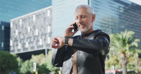 Smiling Man Using Smartphone and Checking Watch in Urban Setting