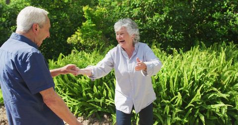 Joyful Senior Couple Dancing Outdoors in a Garden