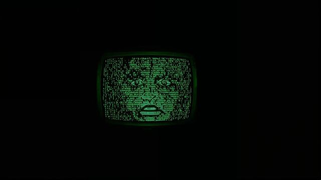 Vintage crt monitor with ascii face illuminated in neon green