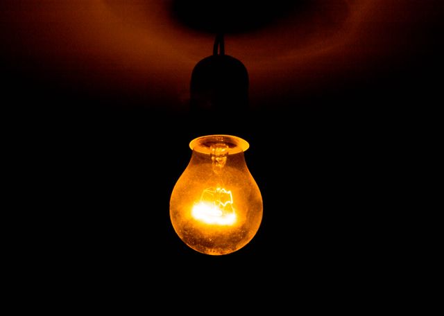 Glowing Incandescent Light Bulb in Dark Room - Download Free Stock Photos Pikwizard.com