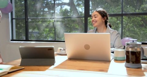 Office team members celebrating with cake and balloons