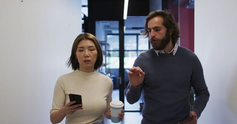 Business Colleagues Walking in Modern Office with Gadgets