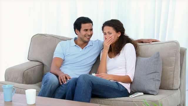 A couple is seated on a comfortable couch at home, showing an emotional reaction to a scene on television. They are portraying feelings of suspense and surprise while watching the movie. Perfect for advertising streaming services, promoting new films or entertainment platforms, and for depicting home lifestyles or date night concepts.