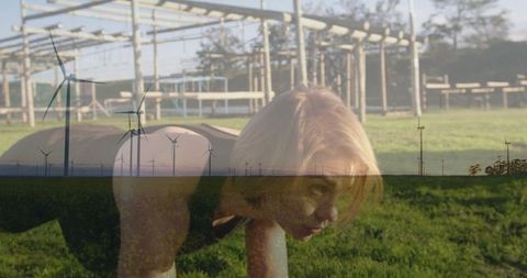 Woman exercising outdoors with wind turbines for eco-friendly fitness