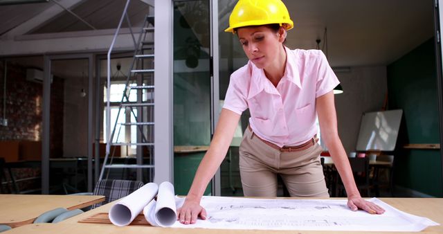 Female Architect Studying Blueprints Indoors - Download Free Stock Images Pikwizard.com