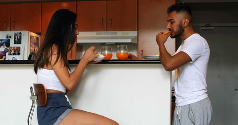 Young couple eating breakfast together in modern kitchen