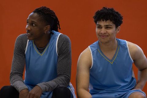 Diverse Basketball Teammates Relaxing on Sideline Bench with Matching Jerseys