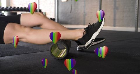 Woman rolling legs on foam roller for muscle recovery with rainbow heart overlays