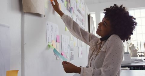 Fashion Designer Brainstorming on Inspiration Board in Office