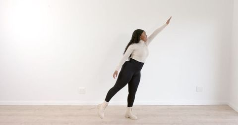 Woman Stretching Gracefully in Minimalist Dance Studio