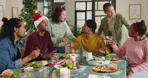 Diverse Friends Celebrating Christmas around Festive Table