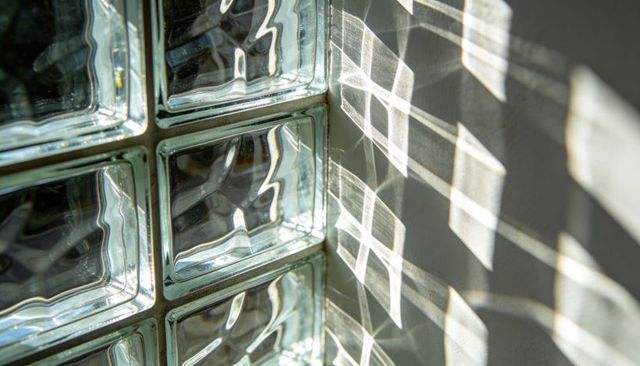 Sunlight Through Glass Block Grid Casting Geometric Shadows on Plaster Wall Minimalist Detail