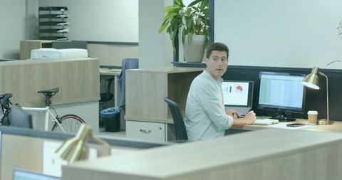 Professional analyzing charts in office with bicycle and modern workspace