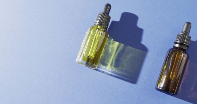 Essential Oil and Serum Droppers on Blue Background - Download Free Stock Images Pikwizard.com