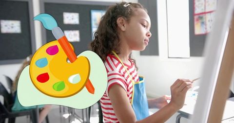 Young girl painting at easel in classroom wearing blue apron and striped tee focused on canvas