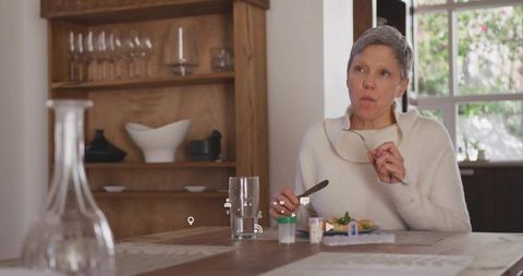 Senior Woman Contemplating Meal in Cozy Rustic Dining Room