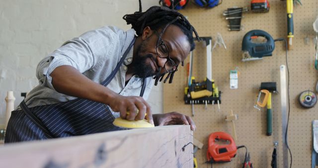 Skilled Craftsman Sanding Wood in Workshop with Tools on Pegboard - Download Free Stock Images Pikwizard.com