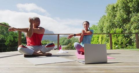 Happy Couple Stretching with Virtual Fitness Session on Terrace