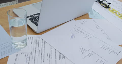 Messy Home Office Desk with Laptop and Documents