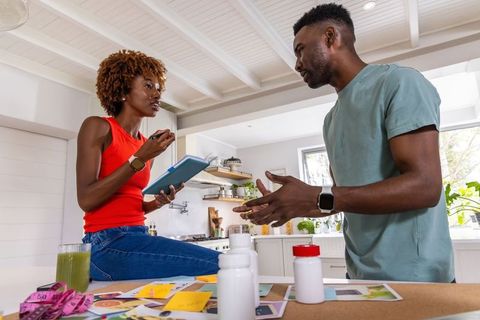 African american couple discussing health plan and budget at bright kitchen counter