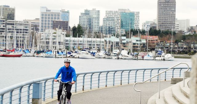 Man Cycling along Urban Waterfront Pathway with City Skyline - Download Free Stock Images Pikwizard.com